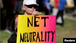 FILE - A protester attends a pro-net neutrality Internet activist rally in Los Angeles, California.