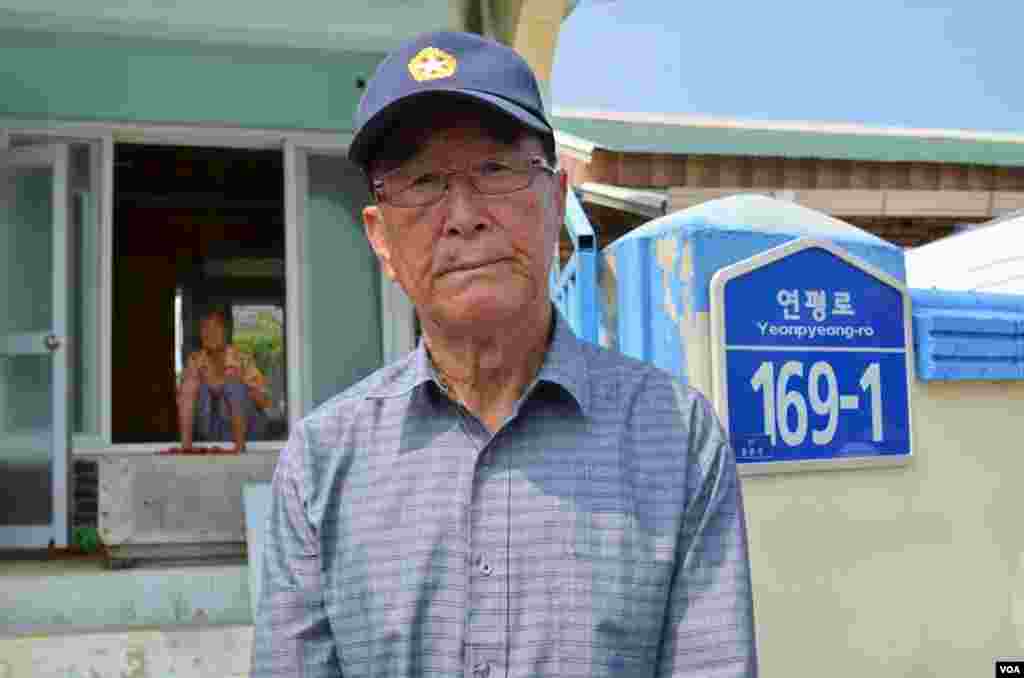 &Ocirc;ng Kim Yoo-sung, 84 tuổi, đứng trước cổng nh&agrave; &ocirc;ng vốn bị ph&aacute; hủy nghi&ecirc;m trọng v&igrave; ph&aacute;o k&iacute;ch của Bắc Triều Ti&ecirc;n. (Photo: VOA/Steve Herman)