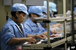 FILE - Chinese women work at a technology factory in southern China.