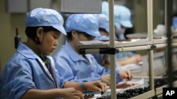 FILE - Chinese women work at a technology factory in southern China.