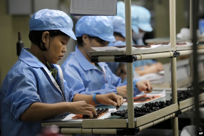 FILE - Chinese women work at a technology factory in southern China.