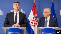European Commission President Jean-Claude Juncker, right, and Croatian Prime Minister Andrej Plenkovic address the media after a meeting at the EU headquarters in Brussels, Wednesday, Feb. 14, 2018.
