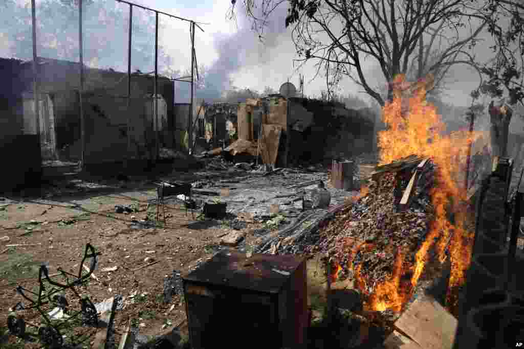 Homes smoulder after being hit by a shell in Donetsk, eastern Ukraine, Sept. 7, 2014.