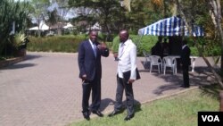 DRC Foreign Minister Raymond Tshibanda (L) and M23 Spokesman Rene Abandi discuss the situation, at DRC peace talks in Kampala, Uganda, Sept. 17. (VOA/A. Hall)