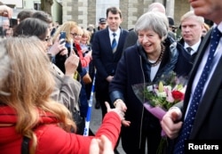 Britain's Prime Minister Theresa May greets people after visiting the scene where former Russian intelligence officer Sergei Skripal and his daughter Yulia were found after they were poisoned with a nerve agent, in Salisbury, Britain, March 15, 2018.
