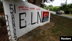 FILE - Graffiti, of rebel group Army Liberation National (ELN), is seen at the entrance of the cemetery of El Palo, Cauca, Colombia, Feb. 10, 2016. 
