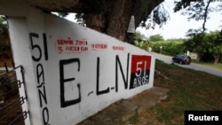 FILE - A graffiti, of rebel group Army Liberation National (ELN) is seen at the entrance of the cemetery of El Palo, Cauca, Colombia, Feb. 10, 2016. 
