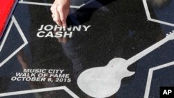 Tommy Cash, the youngest brother of the late Johnny Cash, picks a flower petal off the star presented to Johnny Cash on the Music City Walk of Fame, Oct. 6, 2015, in Nashville, Tennessee. 