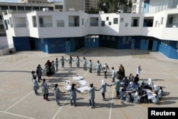 FILE - Palestinian children take part in an activity at a school run by the U.N. Relief and Works Agency in the Shuafat refugee camp in East Jerusalem Oct. 10, 2018.