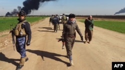 Các thành viên thuộc lực lượng người Kurd Peshmerga và lực lượng an ninh Iraq tuần phòng trên một con đường cách thành phố Kirkuk khoảng 25 km về hướng Tây, mấy ngày sau khi lực lương người Kurd chiếm lại khu vực nằm trong tay nhóm Nhà nuoc Hồi giáo 