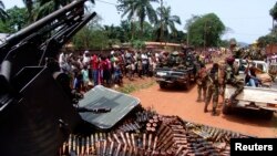 FILE - Armed fighters from the Seleka rebel alliance patrol the streets in pickup trucks to stop looting in Bangui, March 2013.