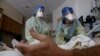 Enfermeras ayudan a un paciente de coronavirus en el hospital Madison Memorial en Reburg, Idaho, el 28 de octubre de 2021.