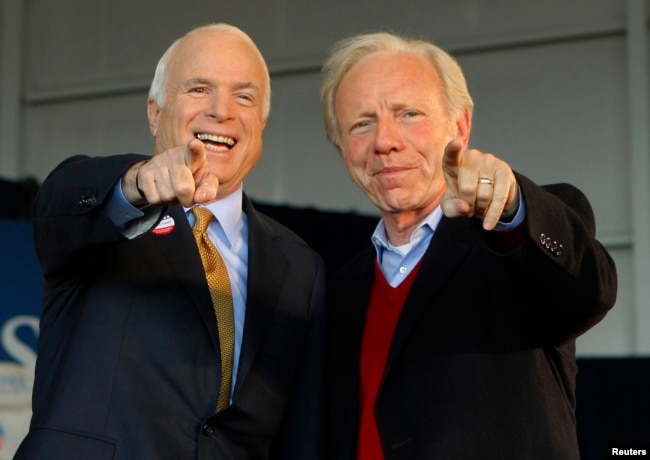 U.S. Republican presidential nominee Senator John McCain (R-AZ) (L) and U.S. Senator Joe Lieberman (I-CT) point to a sign in the crowd at a campaign rally in Grand Junction, Colorado November 4, 2008, the day of the U.S. presidential election.