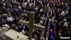 FILE - Worshippers pray during a mass in the morning at the Liuhe Catholic Church in Liuhe village on the outskirts of Qingxu county, northern China's Shanxi province, Sept. 11, 2011. A senior pastor at a church in Hangzhou, China has been replaced and put under investigation for embezzlement, adding to fears of a growing crackdown on Christianity.