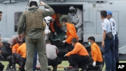 Hải quân Mỹ khiêng thi thể một nạn nhân ra khỏi máy bay trực thăng tại Pangkalan Bun, Indonesia, ngày 2/1/2015.