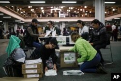 Funcionarios electorales cuentan los votos el domingo, 26 de agosto de 2018 en Bogotá, tras el cierre de las urnas en un referendum para disminuir la la corrupción.