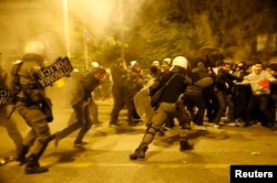 Riot policemen clash with protesters at a rally marking the 41st anniversary of a 1973 student uprising against a U.S. backed military dictatorship in then ruling Greece, near the U.S. embassy in Athens, Nov. 17, 2014.