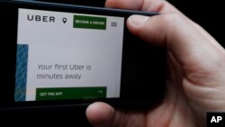 FILE - The Uber website is displayed on a phone in London, Sept. 22, 2017. British and Dutch regulators have fined Uber for what it said were inadequate security measures that left personal data at risk for a cyber attack.
