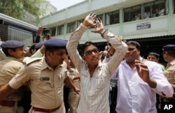 An Indian man convicted for the 2002 Gujarat riots is taken back to jail after the court announced the lengths of the sentences in Ahmadabad, India on June 17, 2016.