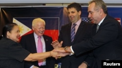 U.S. Assistant Sec. of State for East Asian and Pacific Affairs Kurt Campbell (R), U.S. Assistant Sec. of Defense for Asian and Pacific Security Affairs Mark Lippert (2nd R), Philippines ambassador to the U.S. Jose Cuisia, Philippines Foreign Affairs Undersecretary for Policy Erlinda Basilio (L) join hands during a joint news conference in Manila, December 12, 2012. 