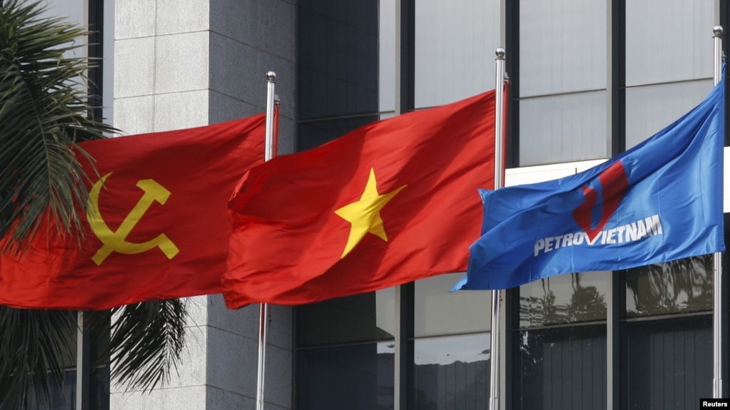 Lá cờ truyền thống của PetroVietnam (phải) tung bay bên cạnh quốc kỳ và cờ của Đảng Cộng sản, ảnh chụp trước trụ sở chính của PetroVietnam ngày 11/1/2016. REUTERS/Kham 