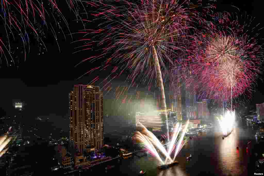 Fireworks explode over Chao Phraya River during the New Year&#39;s celebrations in Bangkok, Thailand.