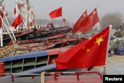 FILE - China's national flags are seen on fishing boats preparing for spring fishing in Lianyungang, Jiangsu Province, China, March 26, 2016.