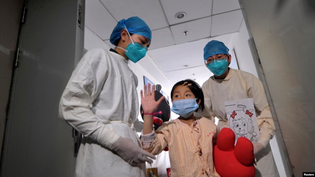 A girl, who was previously infected with the H7N9 bird flu virus, waves as she is being transferred to a public ward from the ICU at Ditan hospital in Beijing, Apr. 15, 2013.