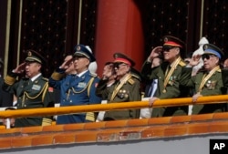 Chinese military officials salute during a parade commemorating the 70th anniversary of Japan's surrender during World War II held in front of Tiananmen Gate, in Beijing, Thursday, Sept. 3, 2015.