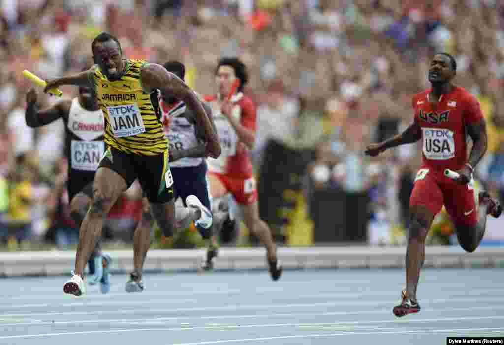 Usain Bolt of Jamaica (L) crosses the finish line ahead of Justin Gatlin of the U.S. (R) to win the men's 4x100 metres relay final during the IAAF World Athletics Championships at the Luzhniki stadium in Moscow August 18, 2013. REUTERS/Dylan Martinez (RUS