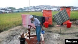 Seoran pengungsi Rohingya memompa air untuk minum tidak jauh dari lokasi jamban di Cox's Bazar, Bangladesh.