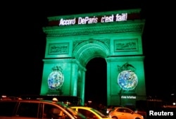 FILE - The Arc de Triomphe is illuminated in green with the words "Paris Agreement is Done", to celebrate the Paris U.N. COP21 Climate Change agreement in Paris, France, Nov. 4, 2016.