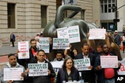 Uber drivers protest next to the Charging Bull statue in New York's financial district, May 8, 2019. The protests arrive just ahead of Uber's initial public stock offering, which is planned for May 10, 2119.