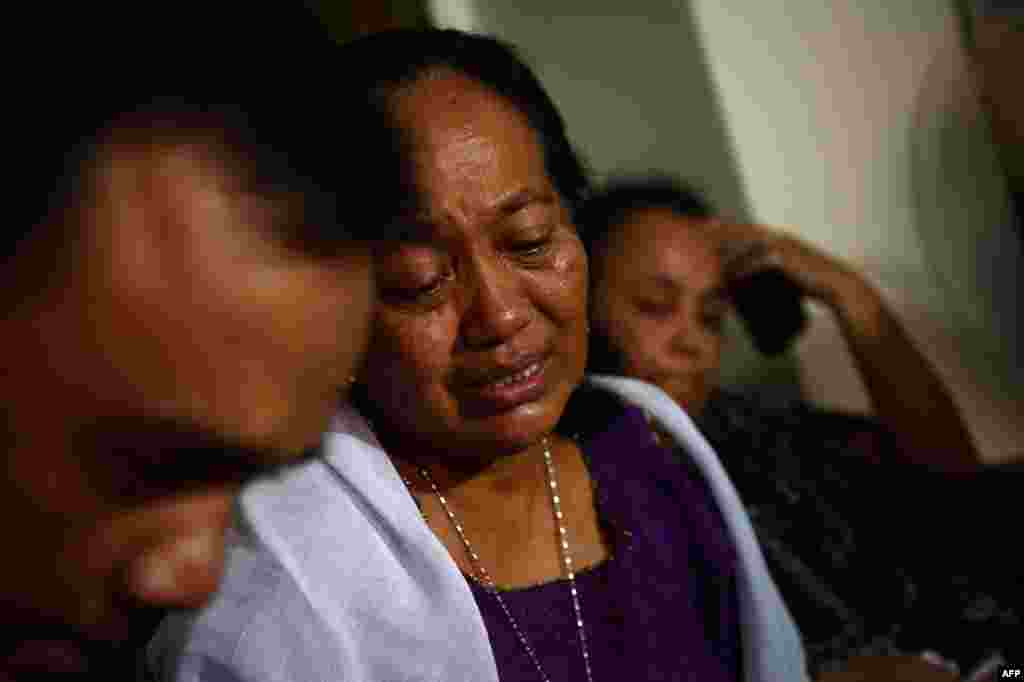 Grieving Indonesian Yuriah Tanzil (C), sister of Ninik Yuriani, a passenger of Malaysia Airlines flight MH17, is comforted by a relative in the family residence in Jakarta after the plane crashed in Ukraine Thursday.