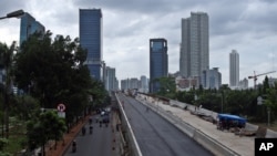 FILE - In this Jan. 11, 2013 photo, workers build an elevated highway in Jakarta, Indonesia. 
