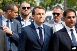 French centrist presidential candidate Emmanuel Macron, center, next to Mourad Franck Papazian, left, co-president of France's Armenian Organizations Coordination Council (CCAF), right, arrives for a ceremony marking 102nd anniversary of the slaying of Armenians by Ottoman Turks in a brief ceremony in Paris, April 24, 2017.