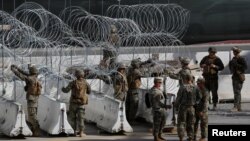 U.S. Marines help to build a concertina wire barricade at the U.S. Mexico border in preparation for the arrival of a caravan of migrants at the San Ysidro border crossing in San Diego, California, Nov. 13, 2018.