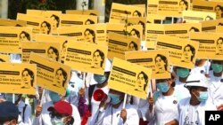 Medicals students display images of deposed Myanmar leader Aung San Suu Kyi during a street march in Mandalay, Myanmar. By midday, security forces had blocked the main road in downtown Mandalay to prevent the protesters from gathering.