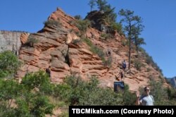 National parks traveler Mikah Meyer stands at the foot of Angels Landing, a massive rock formation that towers 425 meters above the canyon floor.