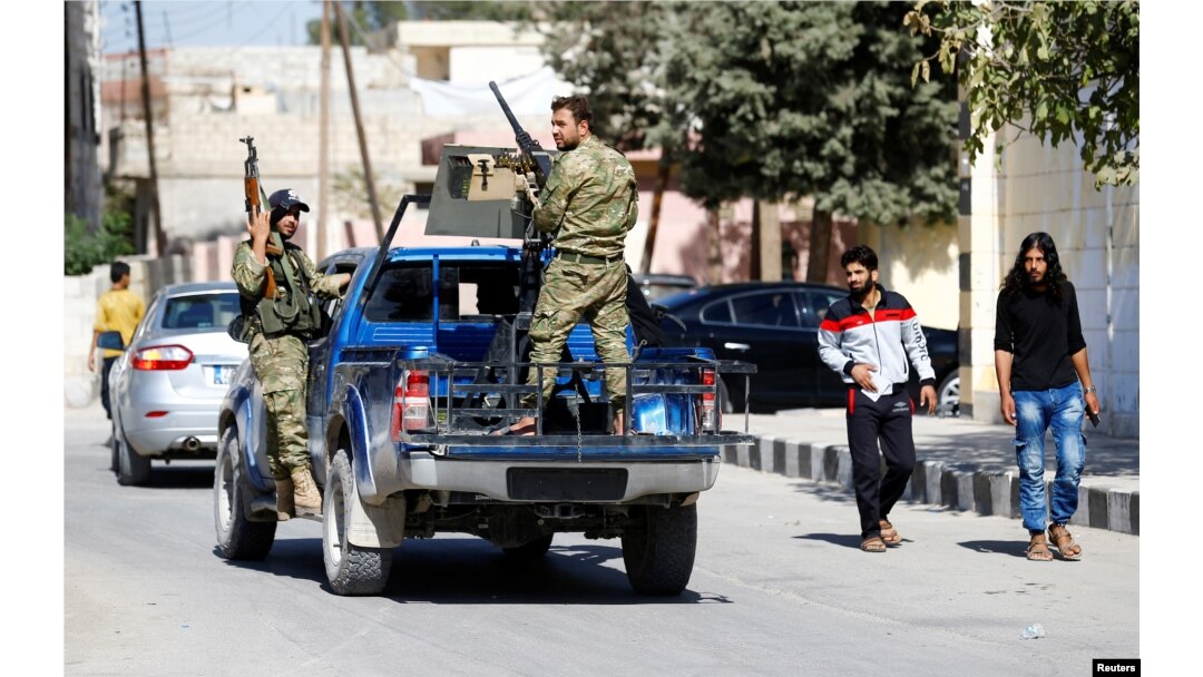 FILE - Members of Turkish-backed Free Syrian Army (FSA) patrol in the border town of Jarablus, Syria.