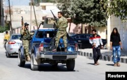 FILE - Members of Turkish-backed Free Syrian Army (FSA) patrol in the border town of Jarablus, Syria.