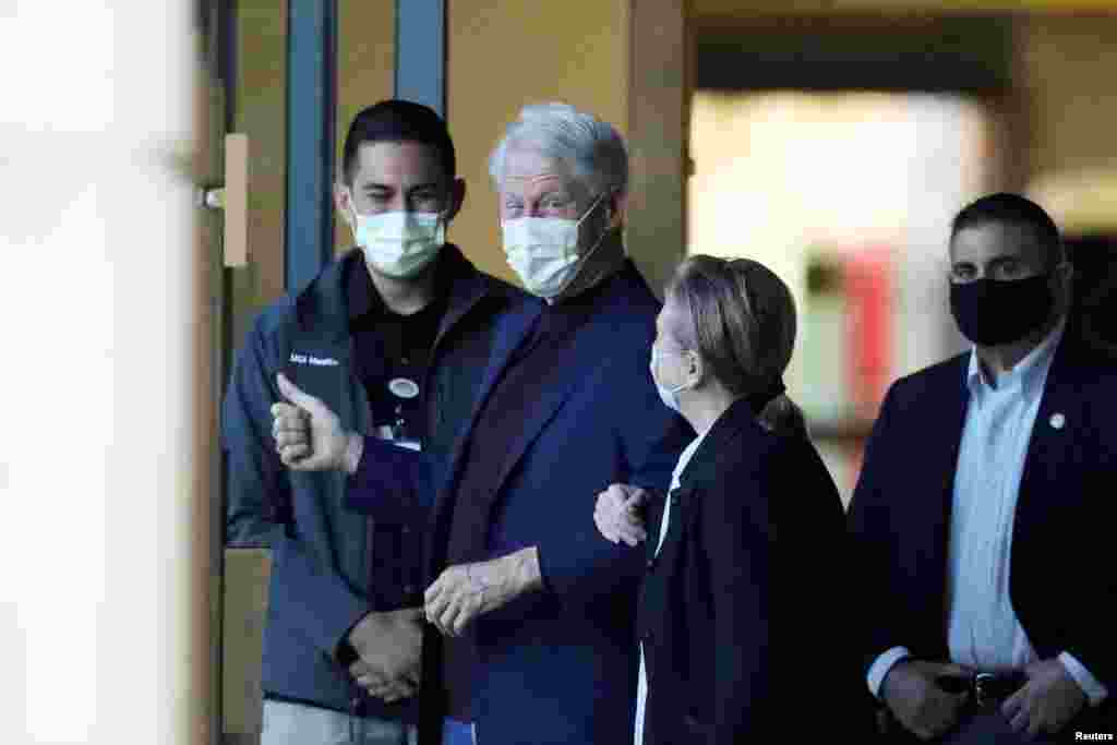 Former U.S. President Bill Clinton, accompanied by his wife, former Secretary of State Hillary Clinton, walks out of University of California Irvine Medical Center, in Orange, California.