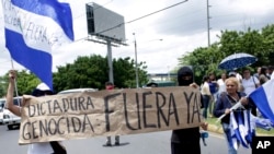 Banner: "Genocidal Dictatorship Out Now" during a demonstration demanding the resignation of President Daniel Ortega and the release of all political prisoners, Managua, Nicaragua. (July 30, 2018.)