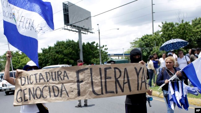 Manifestantes apoyan a periodistas recientemente atacados mientras cubrían protestas que exigían la renuncia del presidente Daniel Ortega, en Managua, Nicaragua, el lunes, 30 de julio de 2018.
