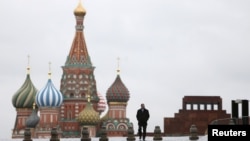FILE - A man walks along Red Square, with the mausoleum of Soviet state founder Vladimir Lenin, right, and St. Basil's Cathedral seen in the background, in central Moscow, Russia, Dec. 21, 2015. 