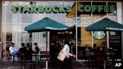 A Muslim woman walks past a Starbucks coffee shop in Rawang outside Kuala Lumpur, Malaysia, July 6, 2017. 