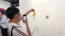 Luis Lu, un amante del arte en Nueva York, se fotografía con la banana pegada a la pared en Art Basel 2019 (Foto: Antoni Belchi)