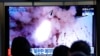 People watch a TV showing a file image of North Korea's missile launch shown during a news program at the Seoul Railway Station in Seoul, South Korea, Jan. 20, 2022.