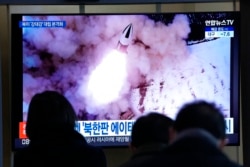 Orang-orang menonton TV yang menampilkan gambar peluncuran rudal Korea Utara yang ditampilkan selama program berita di Stasiun Kereta Api Seoul di Seoul, Korea Selatan, 20 Januari 2022. (Foto: AP)