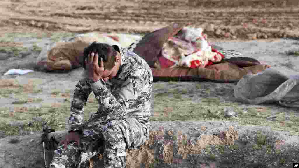 Seorang polisi Irak tampak mengalami trauma setelah menggali kuburan massal dengan lebih dari 20 jenazah, sebagian besar mayat anak-anak, di lokasi kelompok militan ISIS di Mosul.